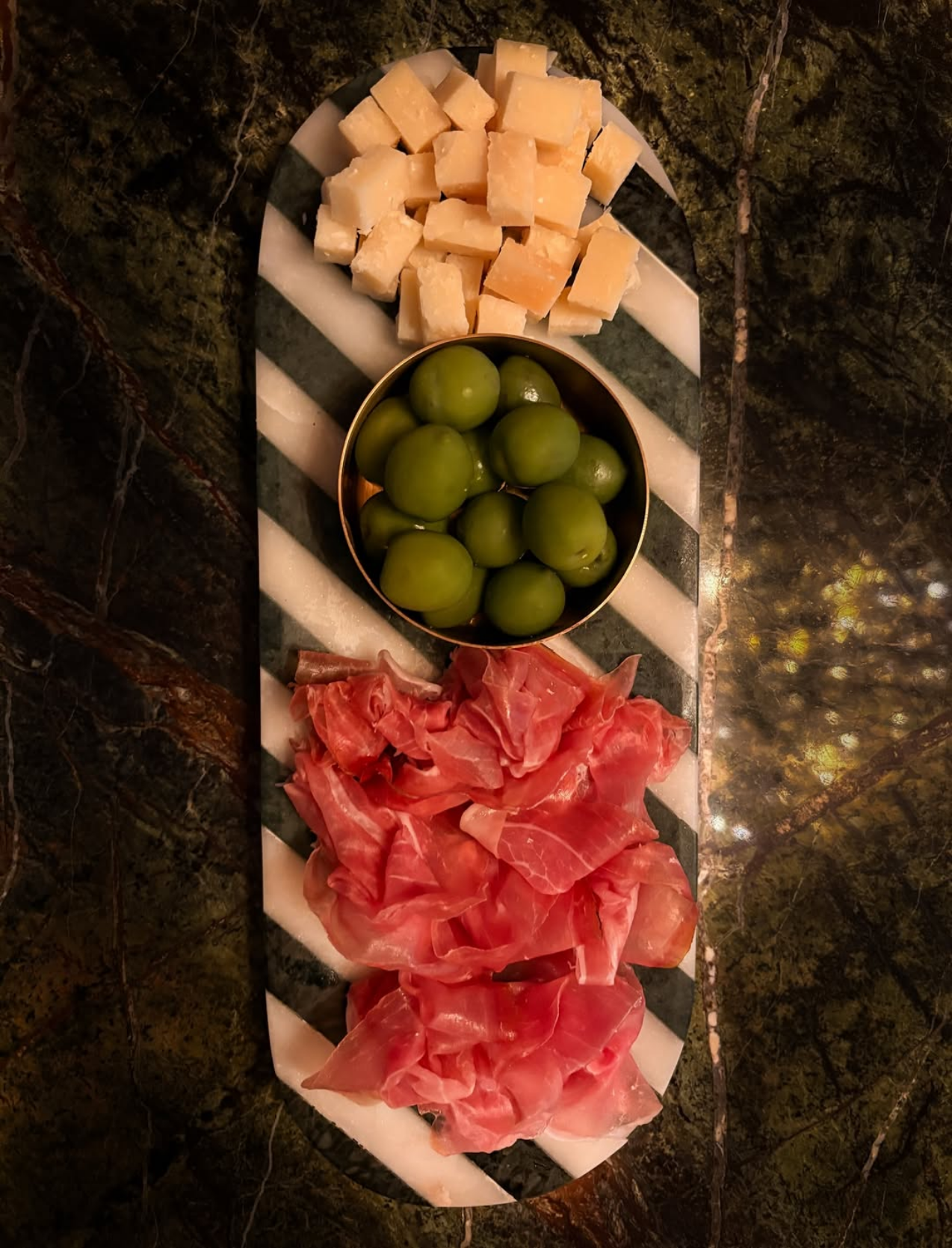 Antipasti-Platte mit Prosciutto, Parmigiano und grünen Oliven